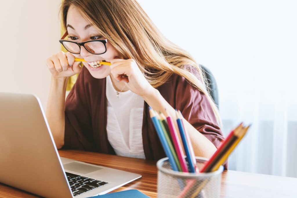 Femme qui réfléchi avec un crayon dans la bouche